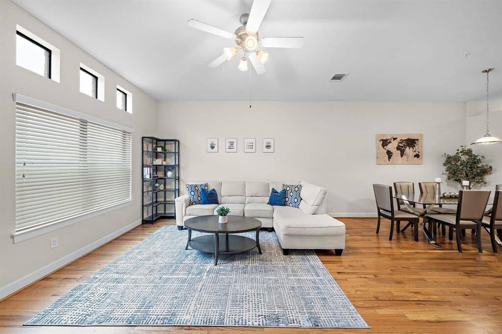 Light streams into this open-concept living and dining room, united by lustrous hardwood floors. With a neutral palette and spacious layout, this is an ideal area for both relaxation and entertainment.