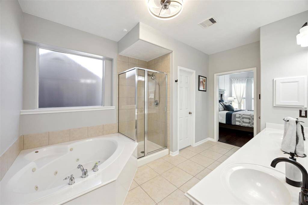 And a look at the primary bathroom towards the bedroom.  Here you can see the shower, linen closet, and medicine cabinet .  And ... the ceiling fan!!