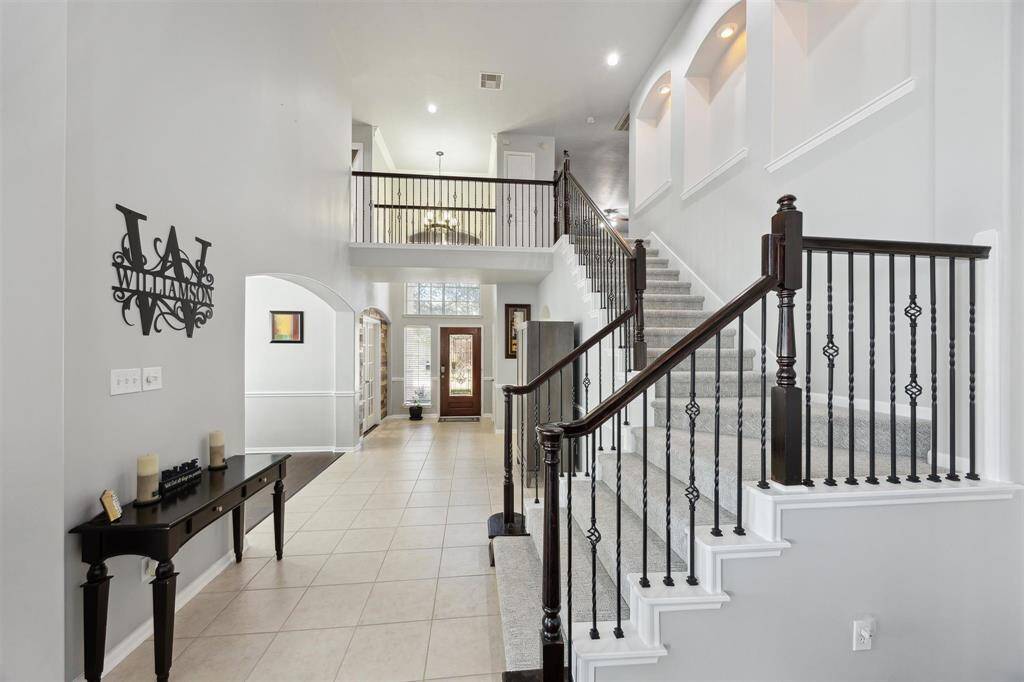 Just beautiful!  Let's head up the stairs.  On the way up, you can put some of your favorite artwork or family pictures in the nooks with lights.  The stairs and entire second floor have plush carpet that was installed in 2024.  To the right at the top of the stairs is a full bath and bedroom.  Straight ahead is a gameroom and then a media room!  Across the catwalk is 2 bedrooms and a full bath.