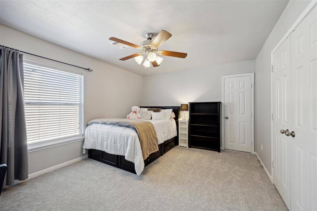 The first of 3 secondary bedrooms upstairs.  The double doors is a closet, and the single door is attic space.