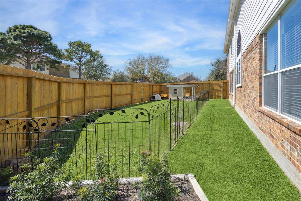 This 21' fencing was added about 2 years ago, so that there is more grassy area in the backyard.  Perfect for dogs and/or a playset.  The fence used to go along the side of the house about 5' out.  Also, notice the drive-through gate down the side of the fence.  And there is gate access straight ahead as well.