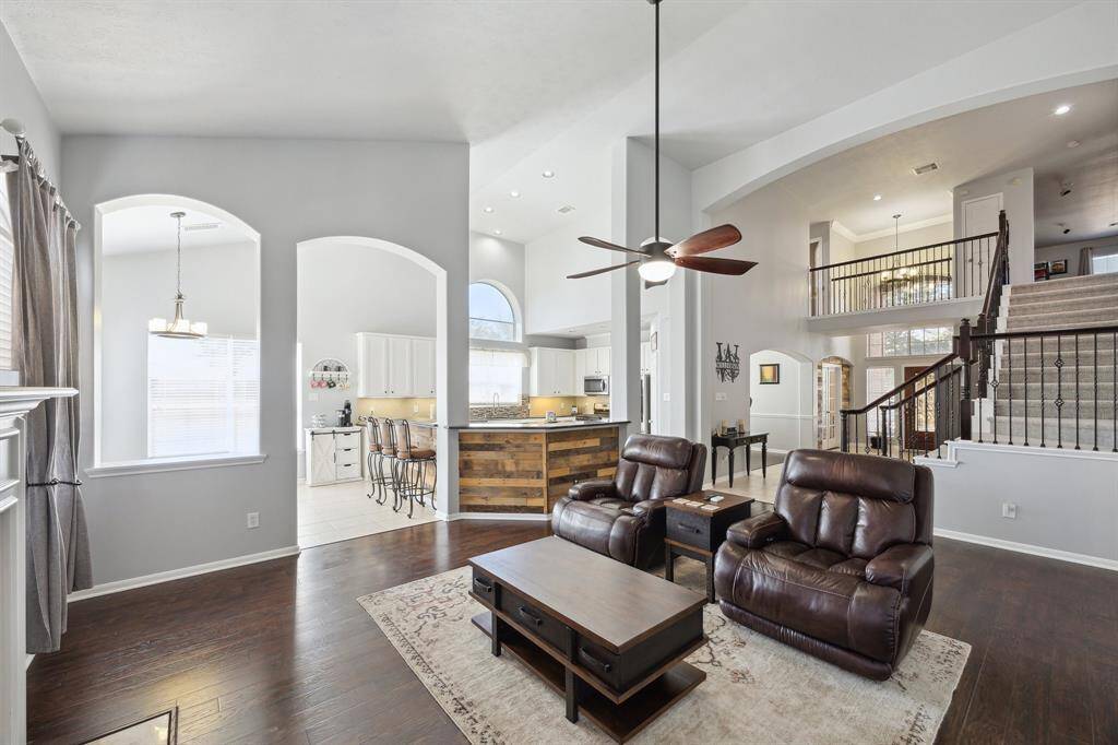 Great view of the first floor!  You can see the front door in the back middle, the stairway with wrought iron banisters, The breakfast room and kitchen straight ahead.  The primary bedroom is out of view, to the right.