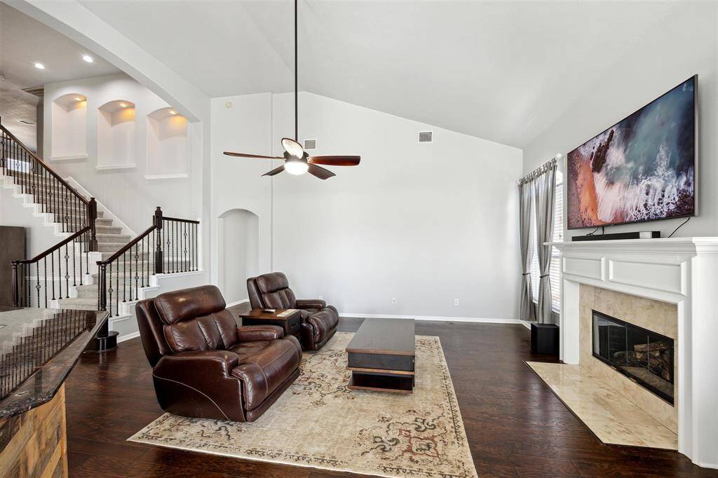 The view from the breakfast room to the family room.  To the right of the lower stairway is the arched walkthrough to the primary retreat.