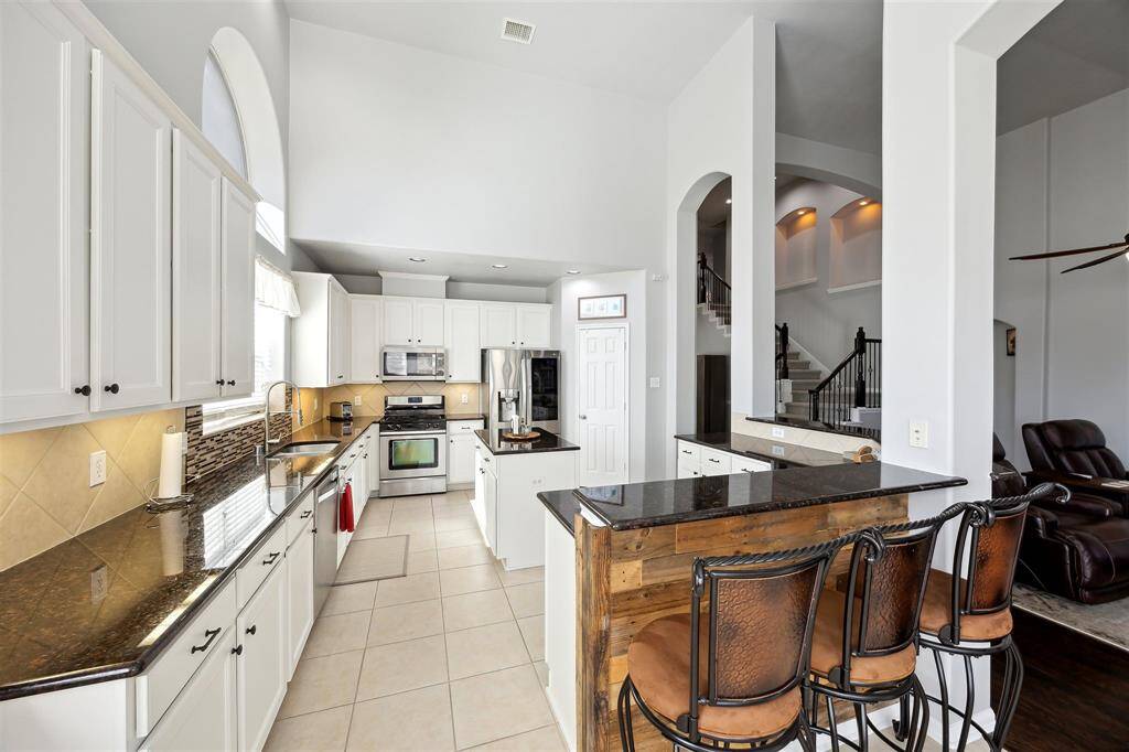 Chef's dream kitchen!  The kitchen is 17' x 14', so plenty of room.  Granite countertops, recent kitchen sink backsplash, gas range, microwave, breakfast bar, tons of storage, island, and walk-in pantry.