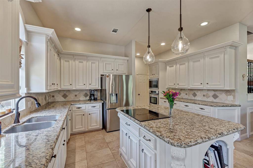 The gournet kitchen has double sink, custom built cabinets and sleek cooktop on the island, with an abundance of storage thoughout.