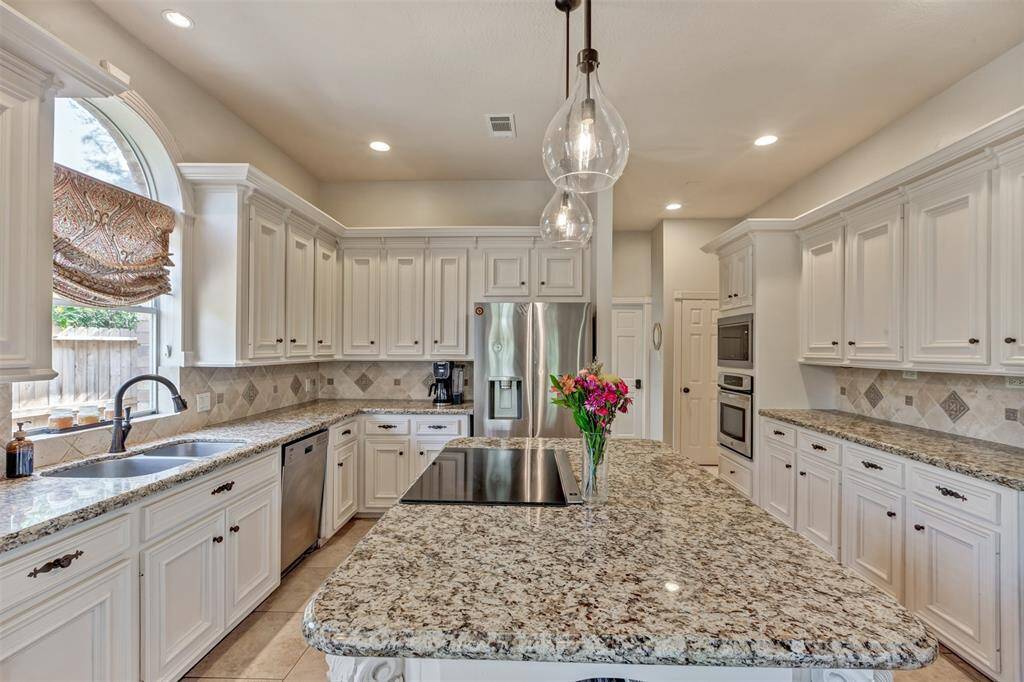 A big window over the double sink lets in natural light and highlights the gorgeous granite countertops!