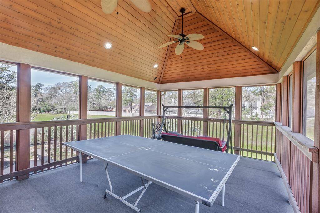 Just outside the game room is the spacious, covered outdoor deck with a wood-paneled ceiling and a ceiling fan. The added outdoor living space is perfect for a game of ping pong or relaxing on the swing overlooking the surrounding greenery and just steps away you can walk from your backyard to the neighborhood park.