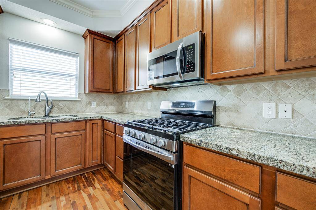 Stainless gas oven and range with microwave above.