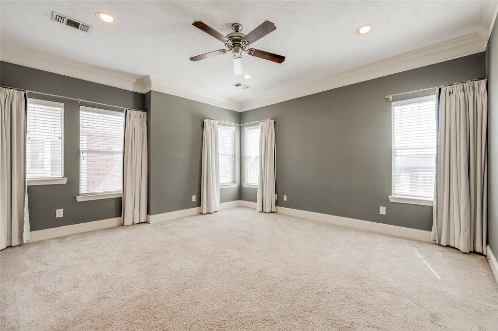 Spacious primary bedroom has designer paint, high-end carpet, ceiling fan, recessed lighting, custom window blinds and drapes.