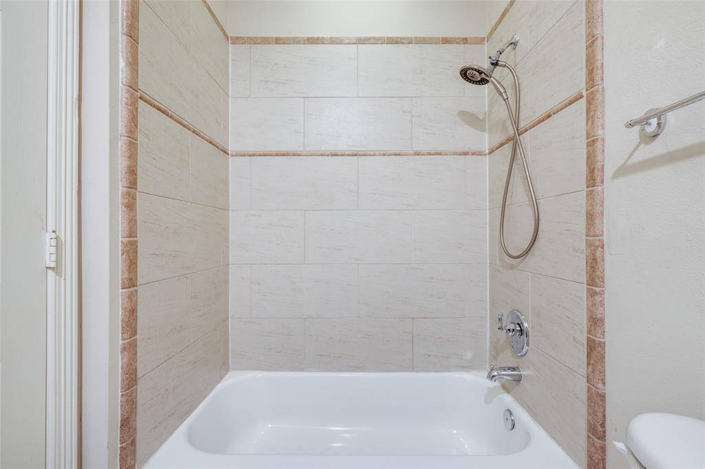 Secondary bedroom bath his tile surround tub/shower.