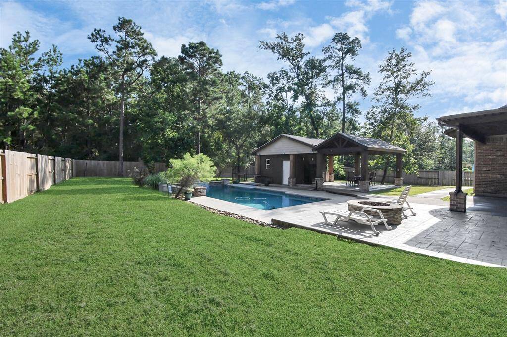 This property features a spacious backyard with a well-maintained lawn, an inviting swimming pool, and a cozy poolside gazebo with ample space for outdoor dining or relaxation. Surrounded by towering trees for privacy, this backyard oasis is ideal for entertaining and leisure.