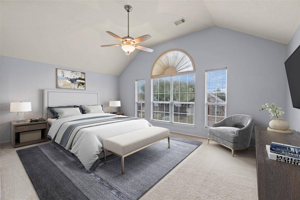 Spacious primary bedroom with vaulted ceilings. virtually staged