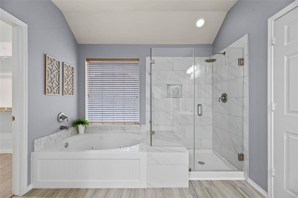 Separate tub and frameless glass shower with upgraded tile.