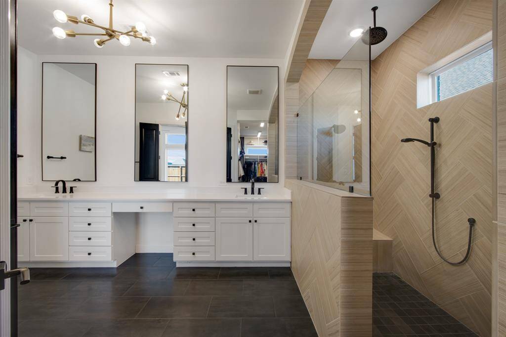 The stunning oversized shower in the primary ensuite is a true focal point, with exquisite tile that extends from floor to ceiling. It’s equipped with both a rain head and a traditional shower head, offering a luxurious and customizable shower experience.