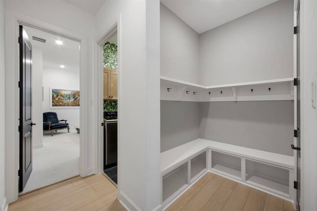 The mud area is both functional and stylish, featuring convenient hooks for coats and accessories. Beneath the bench, ample storage provides an organized space to tuck away shoes, bags, and other essentials, keeping the area tidy and clutter-free.