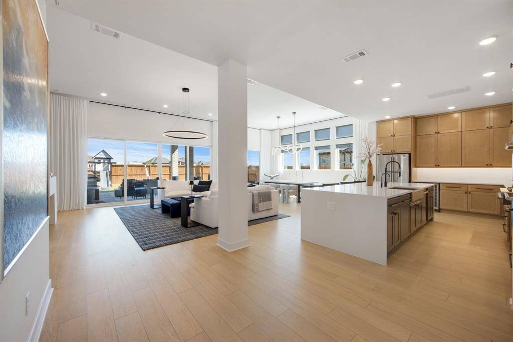 The open floor plan seamlessly connects the living, dining, and kitchen areas, creating a bright and airy space perfect for both entertaining and everyday living. Expansive slider doors offer stunning views of the backyard, bringing the beauty of the outdoors right into the heart of the home.