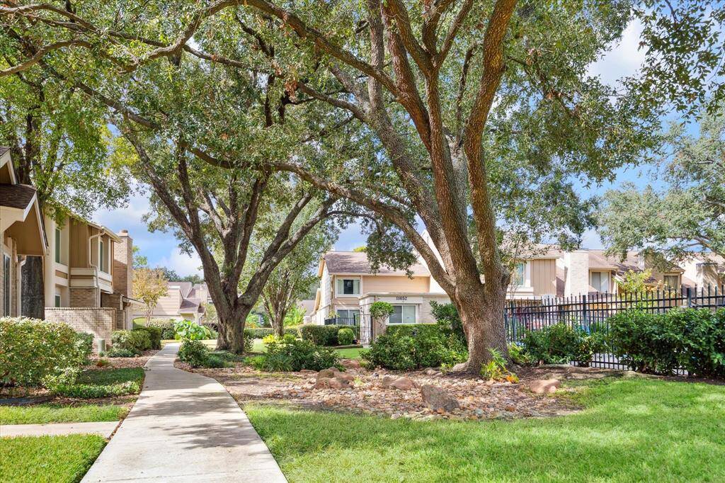 The view from the front door is the community setting with mature trees, well-maintained landscaping, and a walking path