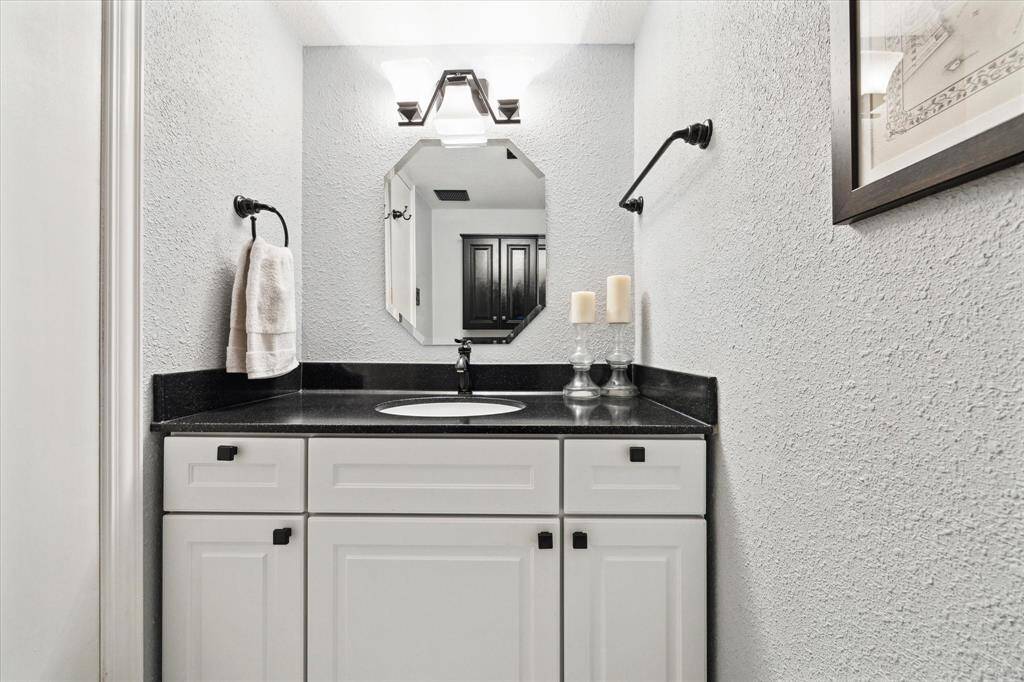 This laundry room features a washer and dryer, ample shelving for storage, and tiled flooring. It's conveniently located indoors on the first floor.