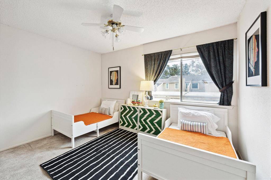 This is a bright secondary bedroom featuring a large window.  This space will accommodate two twin beds or a queemm bed.  It has carpet and is ready for your custom touches.