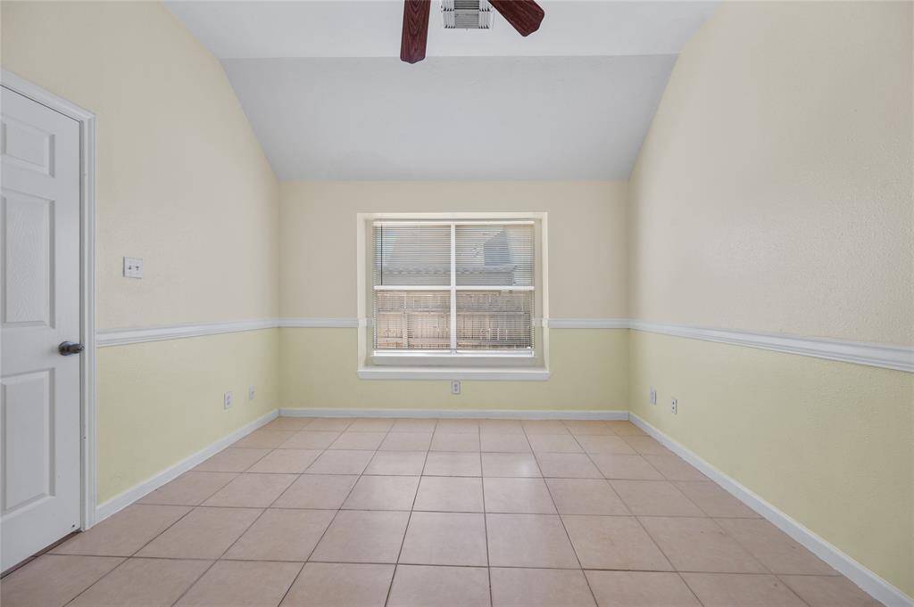 Primary bedroom with ceiling fan and window facing to the backyard.