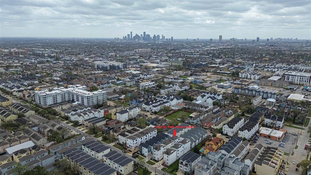 Explore vibrant urban living with this aerial view of modern townhouses and apartments, perfectly positioned for easy city access against a stunning skyline backdrop. Ideal for city enthusiasts.