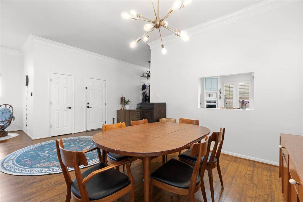 View of dining area from living room looking into the foyer and kitchen.  New fixtures, remote LED ceiling fans, and recessed lighting throughout.
