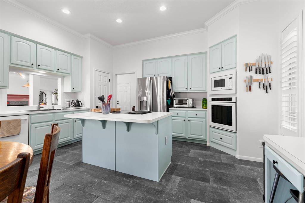 Kitchen has recently painted cabinets, slate tile floors opens to living dining area.