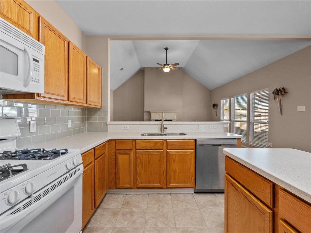 Open-concept kitchen with a breakfast bar, gas range, and walk-in pantry, seamlessly connecting to the living room.