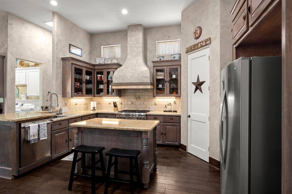 Kitchen with granite countertops and glass door cabinets.