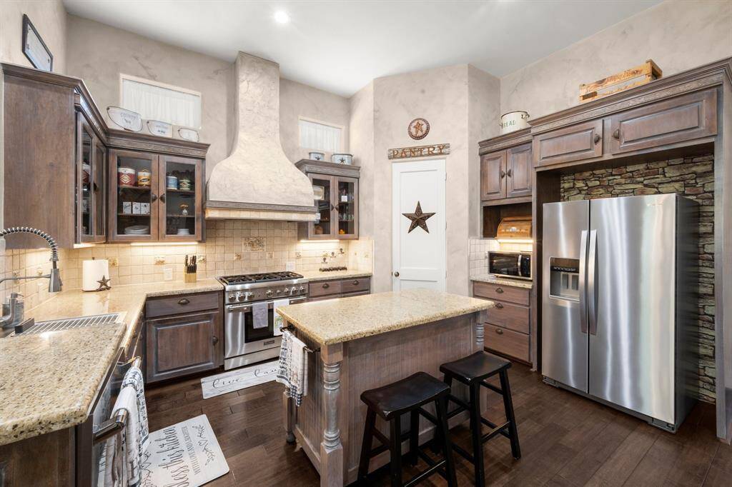 Kitchen with granite countertops and glass door cabinets.