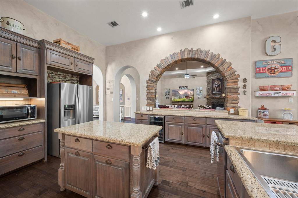 Kitchen with granite countertops and glass door cabinets.