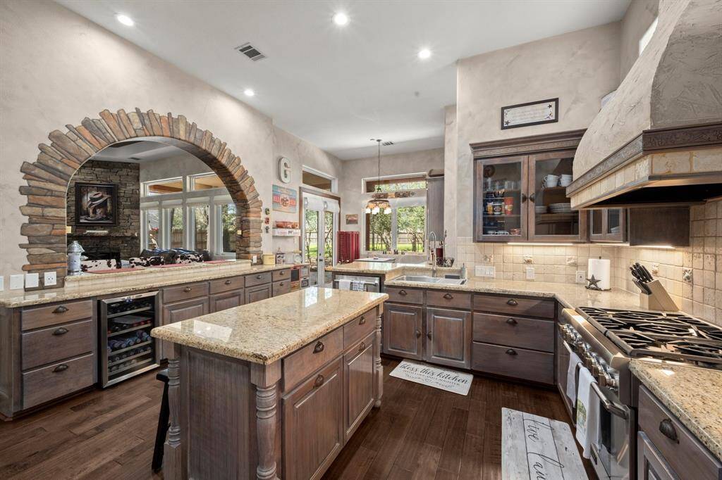 Kitchen with granite countertops and glass door cabinets.
