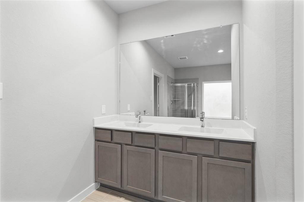 This large primary bath is spacious enough to share! With separate vanities, large closet space, plentiful cabinet and counter space, you are sure to have private area while sharing this bathroom!