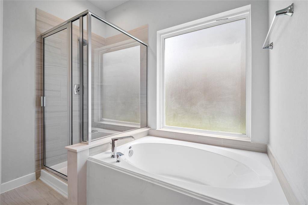 Additional features of the primary bathroom includes a framed walk-in shower with tile surround, separate garden tub for soaking after a long day!