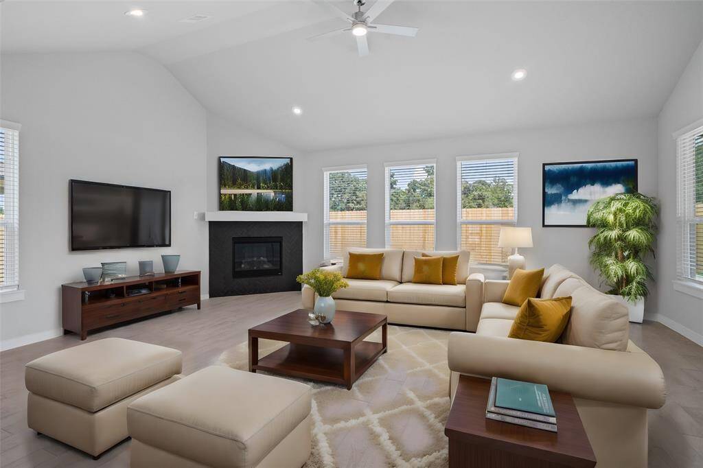 Gather the family and guests together in your lovely living room! Featuring a fireplace with mantel, high ceilings, recessed lighting, ceiling fan, custom paint, gorgeous floors and large windows that provide plenty of natural lighting throughout the day.