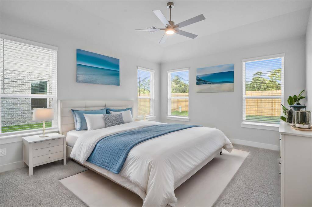 What a wonderful place to come home to, this stunning primary suite greets you with plush carpet, warm custom paint, high ceiling, ceiling fan with lighting, large windows with blinds allowing in natural light brightening up this spacious primary bedroom.