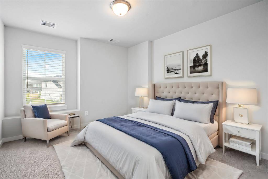 Secondary bedroom features plush carpet, custom paint and a large window with privacy blinds.