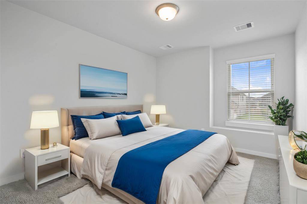 Secondary bedroom features plush carpet, custom paint and a large window with privacy blinds.