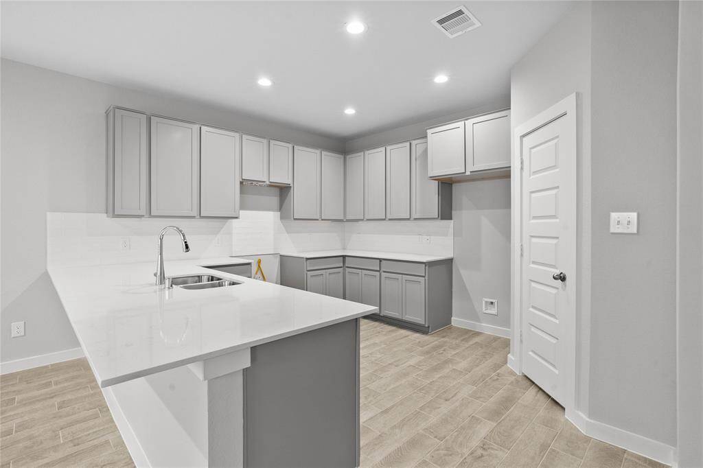 Any chef's dream, this stunning kitchen is perfect for everyday life as well as entertaining family and friends! This kitchen features stained cabinets, quartz countertops, high ceilings with recessed lighting, and a pantry!
