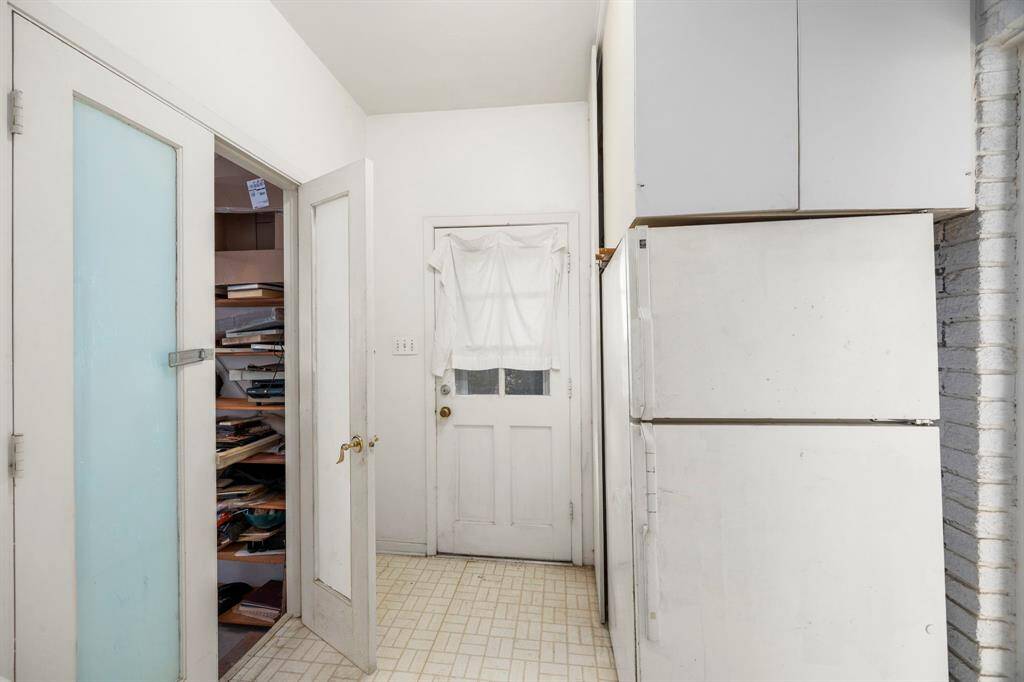 This cozy utility room offers convenient access to spacious backroom workshops, ideal for creative projects or extra storage.