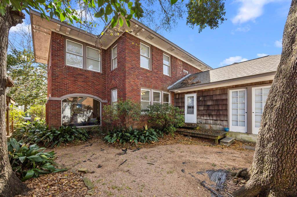 Spacious backyard. Featuring views of large windows and a cozy courtyard, it's surrounded by mature trees, offering a serene outdoor retreat and potential backyard oasis.
