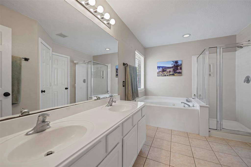 A spa-like ensuite bathroom features dual sink vanity, a large mirror for those quick looks, cabinets and drawers for storage!