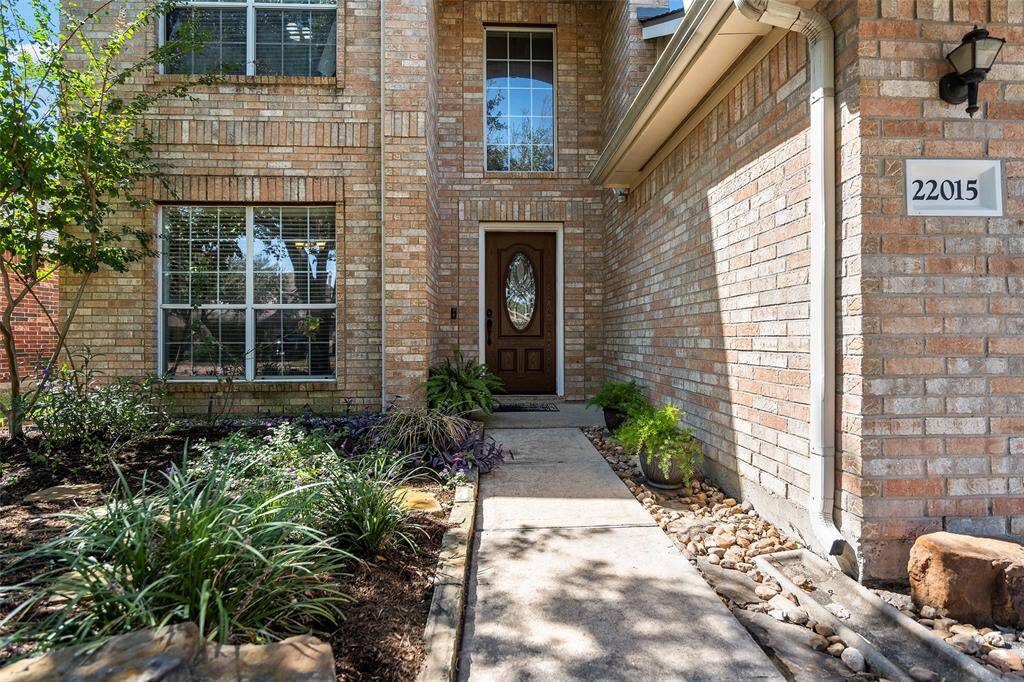 Pretty foliage aligns the walkway and leads you to the leaded glass front door!