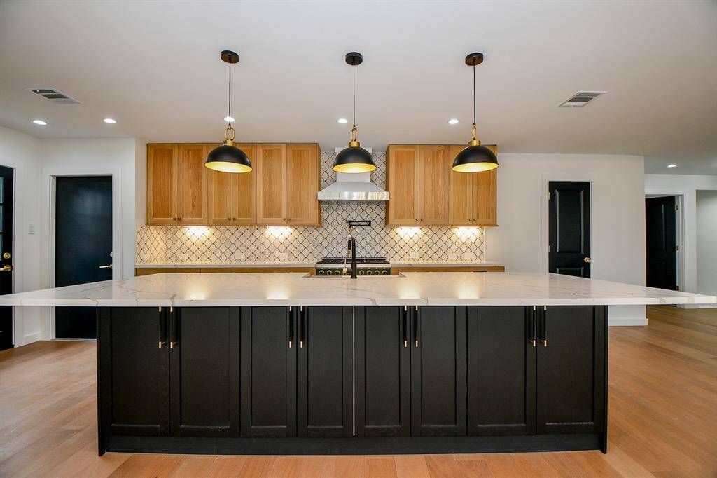 The garage access is conveniently off the kitchen along with a door to the side of the home. The powder room is located to the right before the wine area.