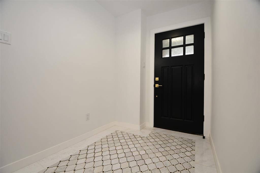 The entry is directly across from the wine room with beautiful marble tile entry.