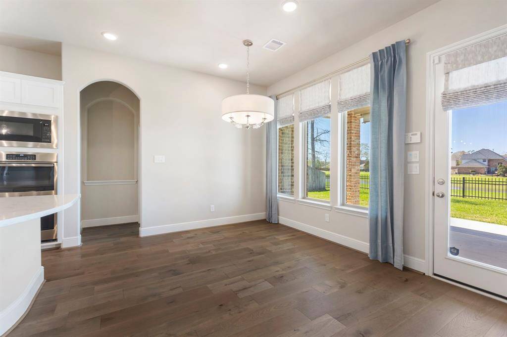 The Breakfast Room with wood flooring and designer lighting, creating the perfect space to enjoy family meals while taking in the beautiful water views!