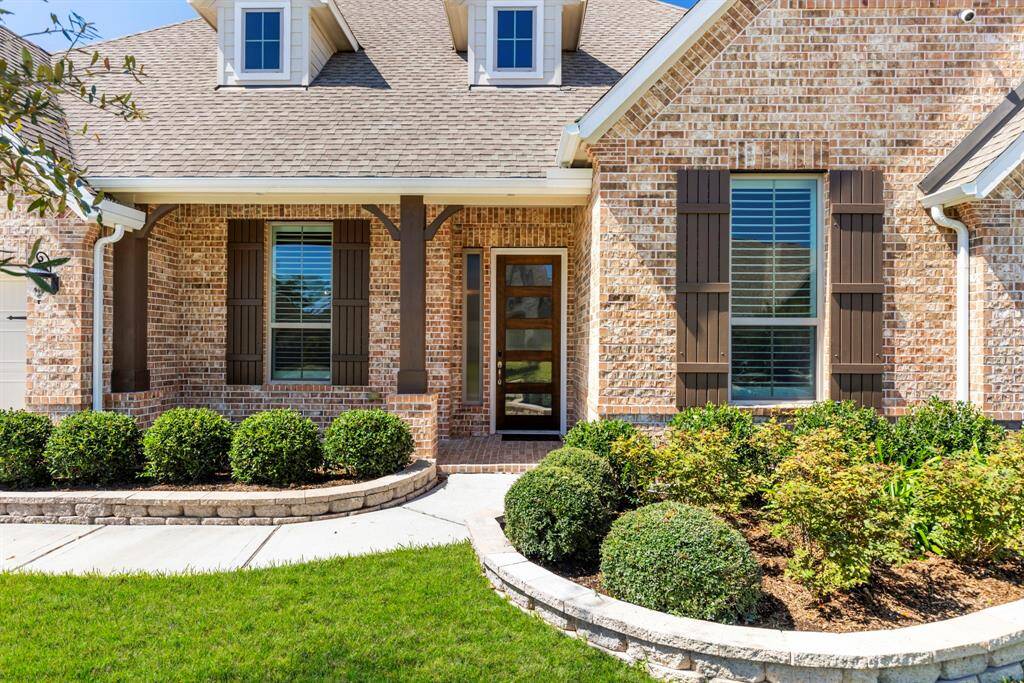 Beautiful elevation with stone accents along flower beds, brick-paved covered front porch, eave downlights, and outside security cameras!