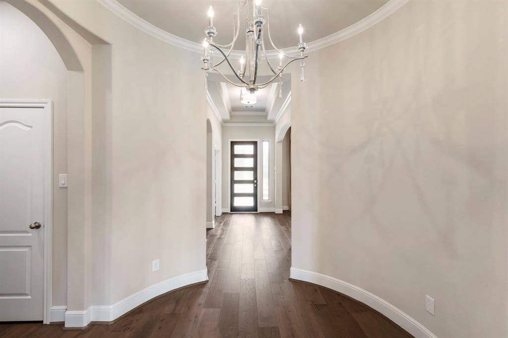 A striking gallery rotunda, highlighted by a statement chandelier, set the stage for this exceptional home!