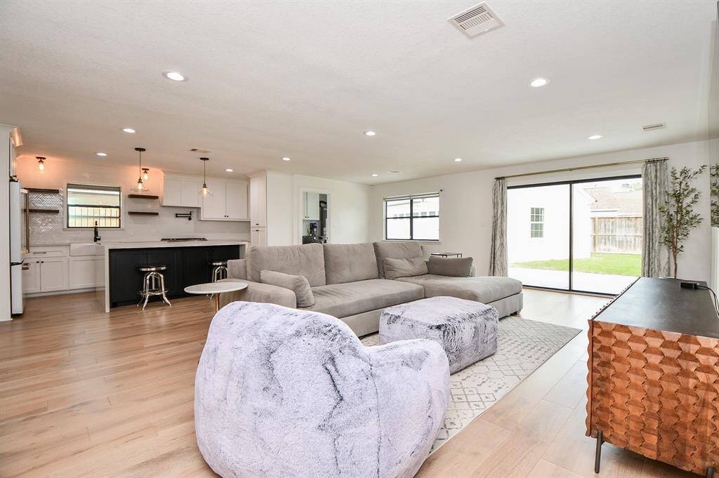 Spacious living area with abundant natural light, open layout, and modern finishes, seamlessly connecting to the kitchen and backyard for effortless entertaining.
