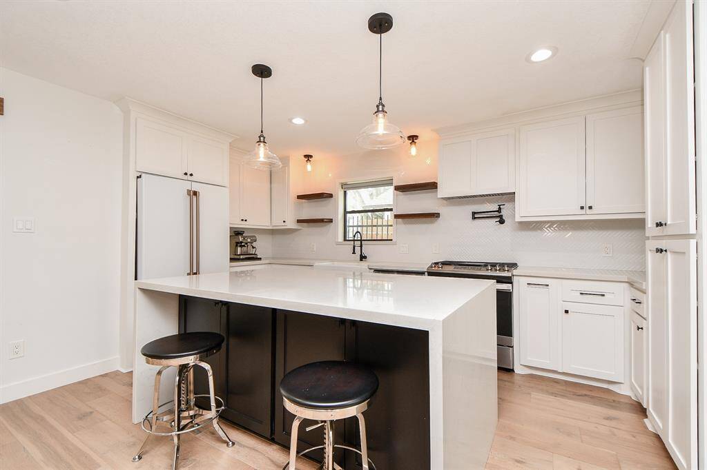 Sleek waterfall countertops add a touch of modern elegance to this kitchen.